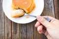 Woman's hand use spoon picking caramel custard cake.