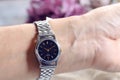 Woman`s hand wearing a silver wristwatch