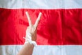 WomanÃ¢â¬â¢s hand with white ribbon shows sign victory over Belarus opposition flag in white and red colors