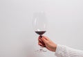 Woman`s hand in a white sweater holding a glass of red wine. Royalty Free Stock Photo