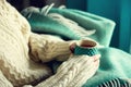 Woman`s hand in woolen sweater holding cup of tea with lemon on a cold day. Copy space. Winter and Christmas holidays Royalty Free Stock Photo