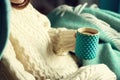 Woman`s hand in woolen sweater holding cup of tea with lemon on a cold day. Copy space. Winter and Christmas holidays Royalty Free Stock Photo