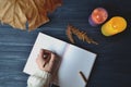 Woman`s hand writing in the notebook. Stylish decoration on the wooden desk. Stylish workplace background Royalty Free Stock Photo