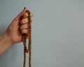 A woman`s hande holding rudraksha beads rosary on the blue background with copy space Royalty Free Stock Photo