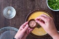 WomanÃ¢â¬â¢s hands adding a pinch of pink Himalayan salt to raw egg mixture in glass bowl, on a wood table Royalty Free Stock Photo