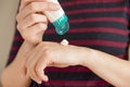 Woman`s hands applying moisturizing hand-cream on