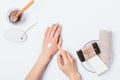 Woman's hands with blue manicure apply cosmetic cream