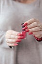 Woman`s hands and a bottle of red orange nail polish Royalty Free Stock Photo