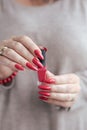 Woman`s hands and a bottle of red orange nail polish Royalty Free Stock Photo