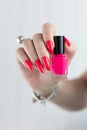 Woman`s hands and a bottle of red orange nail polish Royalty Free Stock Photo