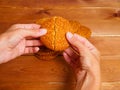 Woman's hands breaking oatmeal cookies