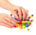 Womans hands with bright manicure taking a colorful candy