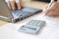 Woman's Hands Calculating Home Finances At Desk