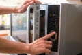 Woman`s Hands Closing Microwave Oven Door And Preparing Food in Royalty Free Stock Photo