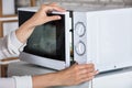 Woman`s Hands Closing Microwave Oven Door And Preparing Food Royalty Free Stock Photo