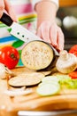 Woman's hands cutting aubergine eggplant