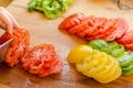 Woman's hands cutting tomato on the kitchen, other fresh vegetab Royalty Free Stock Photo