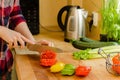 Woman's hands cutting tomato on the kitchen, other fresh vegetab Royalty Free Stock Photo