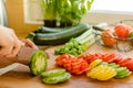 Woman's hands cutting tomato on the kitchen, other fresh vegetab Royalty Free Stock Photo