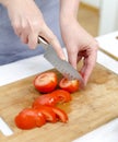 Woman's hands cutting tomatoes