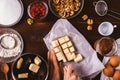 Woman's hands dices butter on wooden table Royalty Free Stock Photo