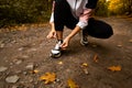 Woman's hands fixing shoelaces on her sneakers. Close cut view. Female trail runner. Morning run concept. Young athletic woman Royalty Free Stock Photo