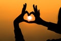 Woman's hands forming a heart shape with sunset silhouette Royalty Free Stock Photo