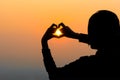 Woman's hands forming a heart shape with sunset silhouette Royalty Free Stock Photo