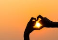 Woman's hands forming a heart shape with sunset silhouette Royalty Free Stock Photo