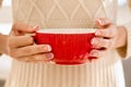 Woman& x27;s hands with french manicure and candy cane pattern on the nails. Woman with beautiful manicure holding big red Royalty Free Stock Photo