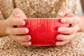 Woman& x27;s hands with french manicure and candy cane pattern on the nails. Woman with beautiful manicure holding big red Royalty Free Stock Photo