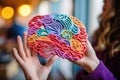 Woman's hands gently hold a colorful brain, symbolizing the richness of neurodiversity and the distinctiveness Royalty Free Stock Photo