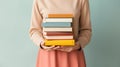 Woman's Hands Grasping Stack of Books Against Light Solid Background. Generative ai