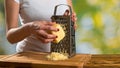 Woman`s hands with grater and cheese