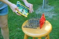 Suet Plus brand bird feed is being placed into cage shaped like house