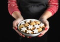 Woman\'s hands hold a bowl with delicious cookies. Christmas time. AI generative