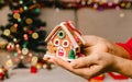 Woman`s hands hold christmas or new year decorated house. Selective focus Royalty Free Stock Photo