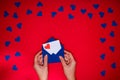 Woman`s hands hold envelope with love letter above red background Royalty Free Stock Photo