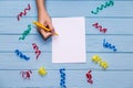 Woman`s hands hold pen and writing on white blank paper with colorful ribbons around Royalty Free Stock Photo