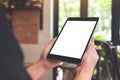 Woman`s hands holding black tablet pc with blank desktop screen in cafe