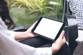 Woman`s hands holding black tablet pc with blank white desktop screen and green nature background Royalty Free Stock Photo