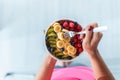 Woman`s hands holding a bowl with fresh fruit while standing at home Royalty Free Stock Photo