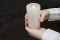 Woman`s hands holding a burning candle on dark background. Close-up Royalty Free Stock Photo