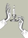 Woman`s hands holding a candlestick with burning candle.