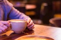 Woman holding a coffee cup at a restaurant