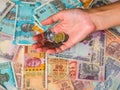 Woman`s hands holding coins over 10, 20, 50, 100, 200, 500 and 2000 Indian rupees