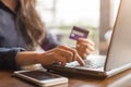 Woman holding credit card and typing on the keyboard of laptop for shopping online. Pays for purchase. Royalty Free Stock Photo