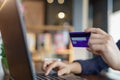 Woman`s hands holding credit card and typing on the keyboard of laptop for shopping online. Pays for purchase. Royalty Free Stock Photo