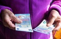 Woman`s hands are holding a few euro coins. Pension, poverty, social problems and the theme of old age. Saving. Royalty Free Stock Photo