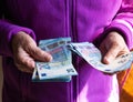 Woman`s hands are holding a few euro coins. Pension, poverty, social problems and the theme of old age. Saving. Royalty Free Stock Photo